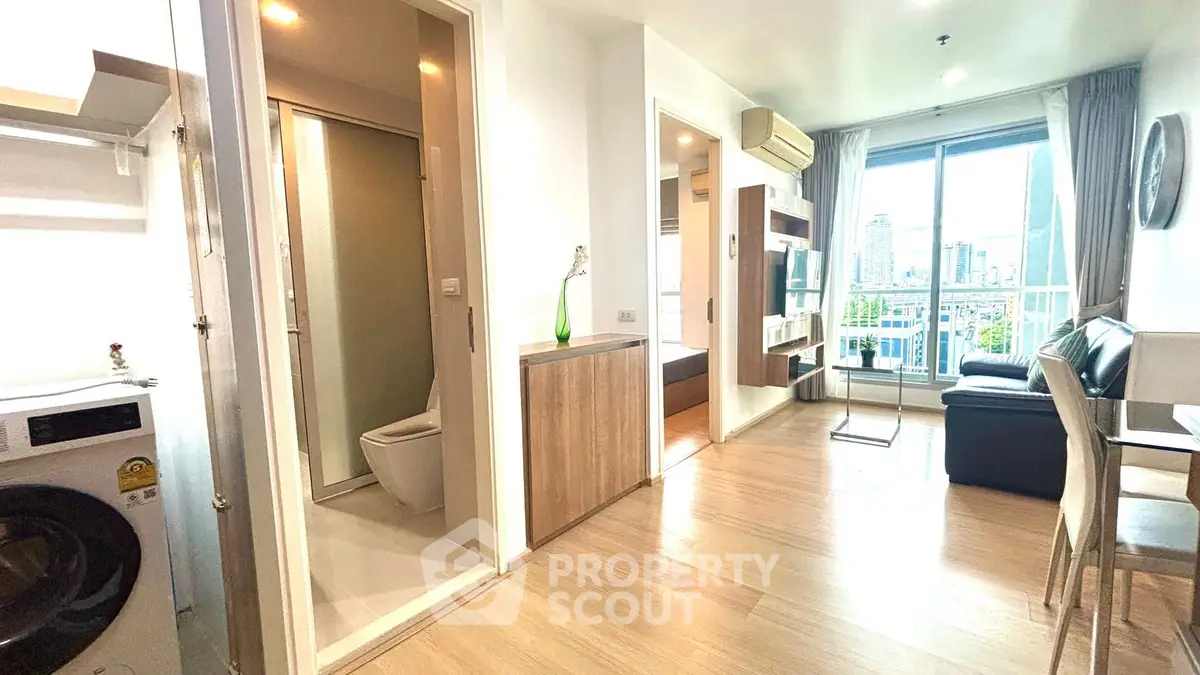 Modern apartment interior with open living space and city view balcony.