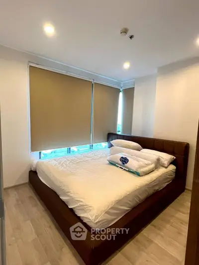 Cozy bedroom with modern furnishings and large windows in a stylish apartment.