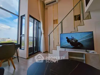 Modern living room with large windows and stylish staircase, featuring a TV and air conditioning.