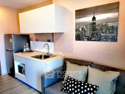 Modern compact kitchen with sleek cabinetry and cozy living area in stylish apartment.