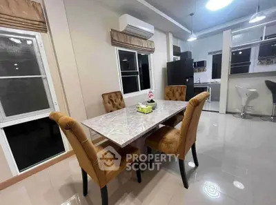 Modern dining area with elegant marble table and plush chairs in a stylish open-layout kitchen.