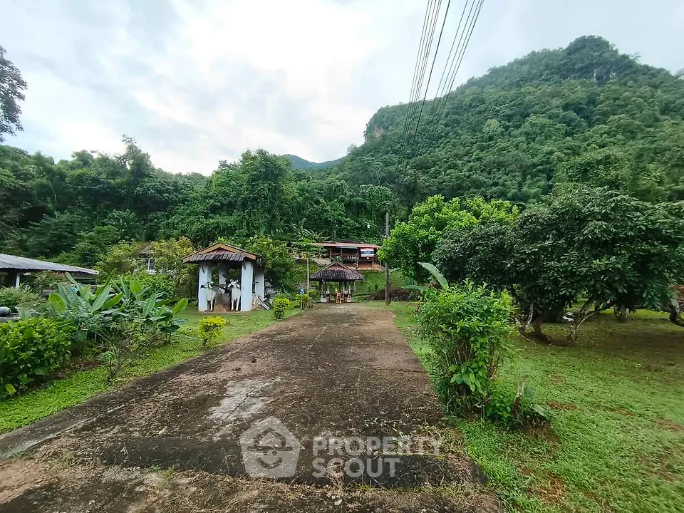 Scenic view of lush green landscape with rustic buildings and mountain backdrop, perfect for nature lovers.