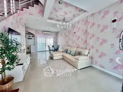 Charming living room with floral wallpaper, elegant chandelier, and cozy seating area in a stylish home.