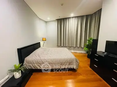 Spacious bedroom with modern decor and wooden flooring