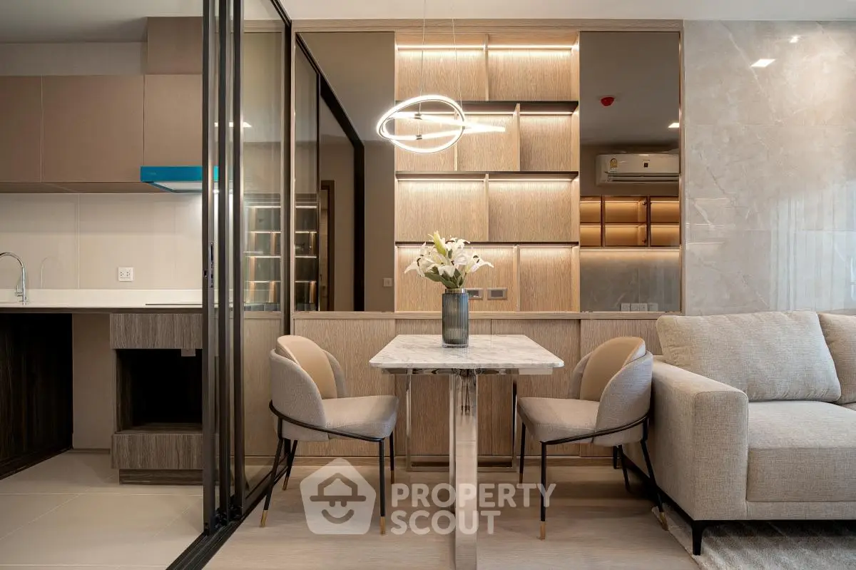 Modern open-plan living room with elegant dining area and stylish lighting in a contemporary apartment.