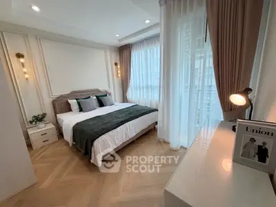 Elegant bedroom with modern decor and large windows for natural light.