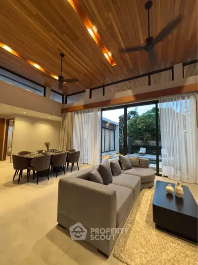 Luxurious living room with high wooden ceiling and garden view