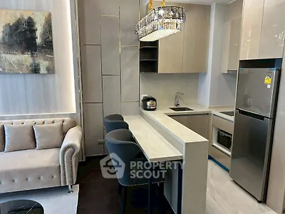 Modern open-layout kitchen with sleek appliances and stylish living area in luxury apartment.