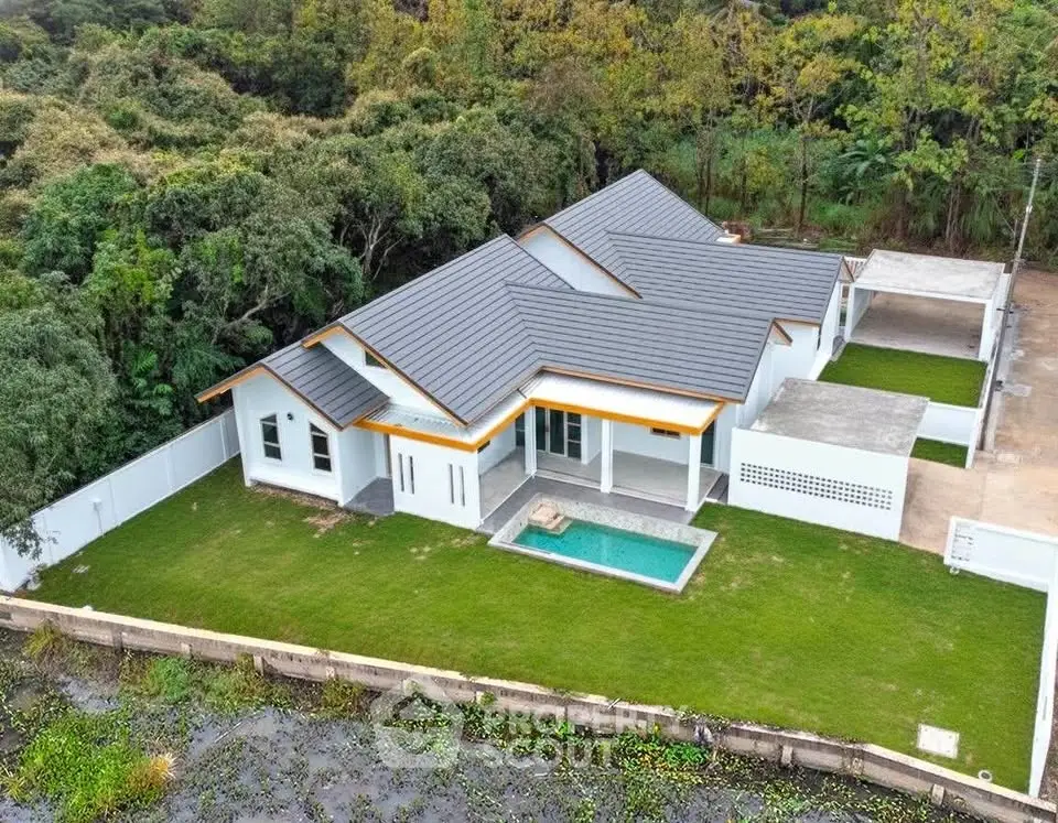 Stunning modern home with private pool and lush greenery, perfect for serene living.