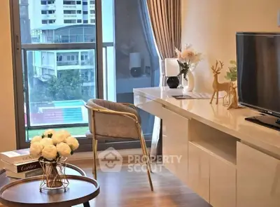 Modern living room with elegant decor and city view, featuring a stylish chair and TV setup.