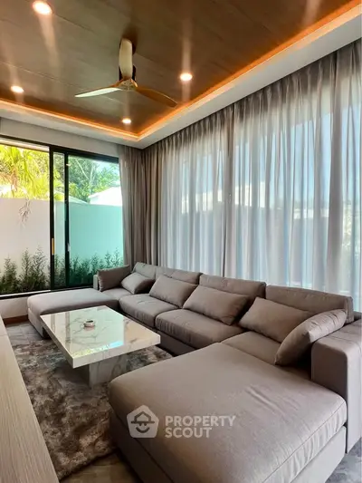Luxurious modern living room with large sectional sofa and elegant ceiling lighting.