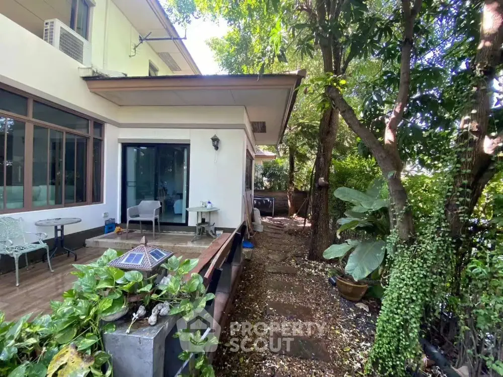 Charming garden view of a modern home with lush greenery and outdoor seating area.