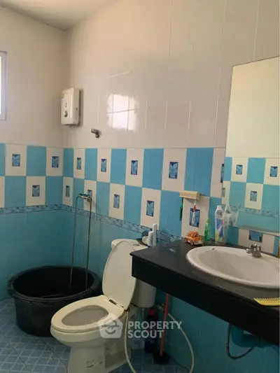 Cozy bathroom with blue tile accents and modern fixtures.