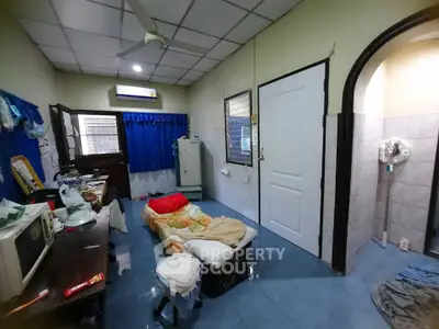Cozy bedroom with blue tiled floor and ceiling fan, featuring a single bed and desk.