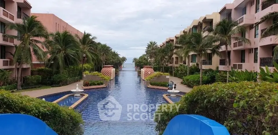 Luxurious beachfront condominium with stunning pool and lush palm trees.