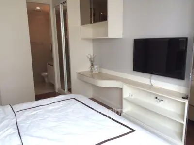 Modern bedroom with wall-mounted TV and sleek furniture design