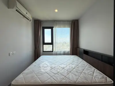 Modern bedroom with large window offering city view and air conditioning unit.