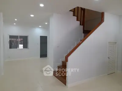 Spacious modern interior with elegant staircase and bright lighting