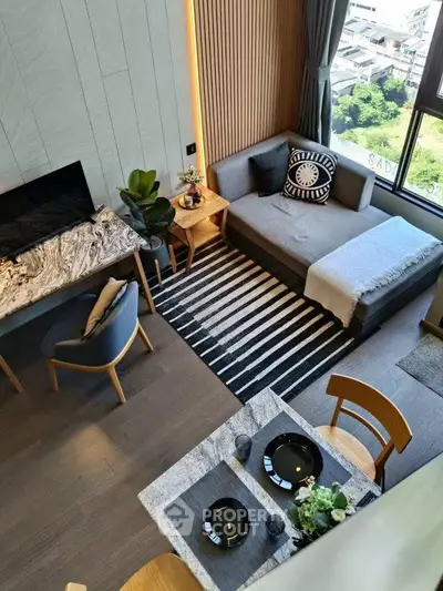 Modern living room with stylish decor and large window offering city view