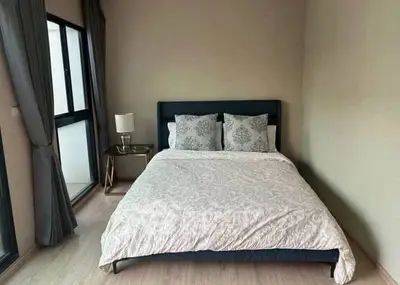 Cozy bedroom with modern decor and large windows for natural light.