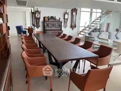 Luxurious dining area with elegant chairs and antique clocks in a spacious open-plan living space.