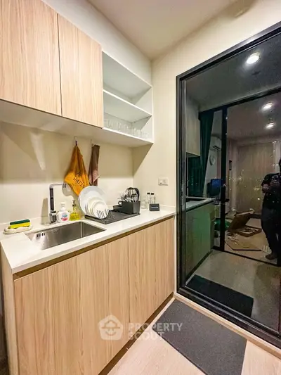Modern kitchen with sleek cabinetry and glass door leading to balcony