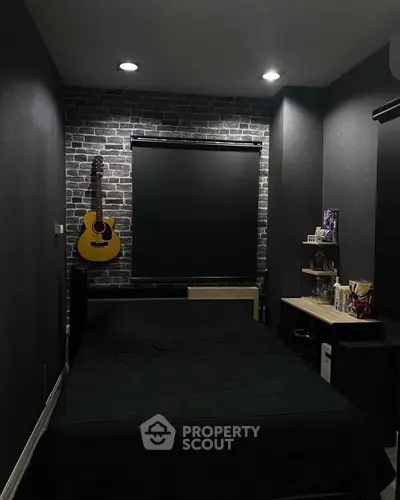 Cozy bedroom with brick accent wall and guitar decor, perfect for music lovers.