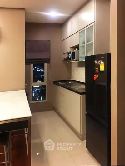 Modern kitchen with sleek cabinetry and city view window
