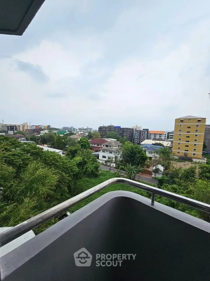 Stunning cityscape view from a high-rise balcony overlooking lush greenery and urban skyline.