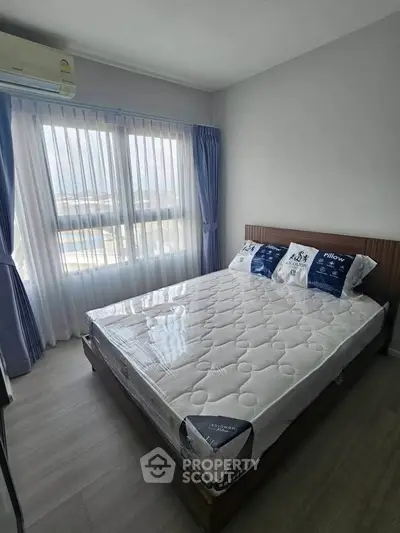 Modern bedroom with large window and stylish decor in a bright apartment.