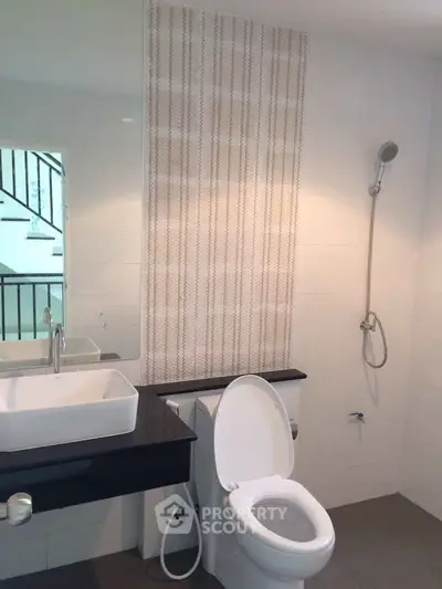 Modern bathroom with sleek fixtures and stylish tile design, featuring a spacious shower area and elegant sink.