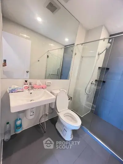 Modern bathroom with glass shower and sleek fixtures in a contemporary apartment.
