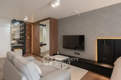 Modern living room with sleek design, featuring a wall-mounted TV and stylish furniture.