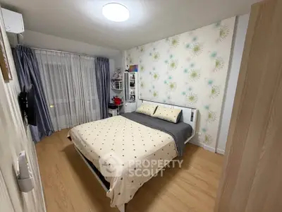 Cozy bedroom with stylish wallpaper and modern furnishings in a well-lit apartment.