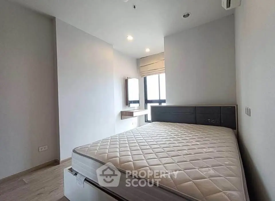 Spacious bedroom with modern design and large windows offering natural light.