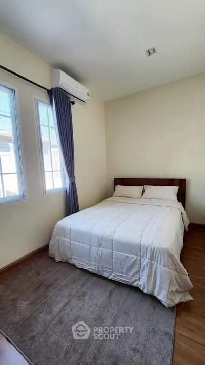 Cozy bedroom with natural light and air conditioning, perfect for relaxation.
