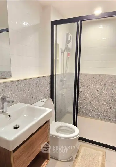 Modern bathroom with sleek shower and stylish sink in contemporary apartment.