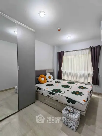 Cozy bedroom with modern decor and ample natural light, featuring a mirrored wardrobe and stylish bedding.