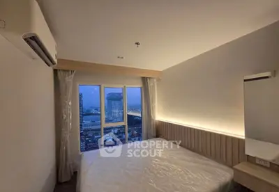 Modern bedroom with city view and ambient lighting in high-rise apartment