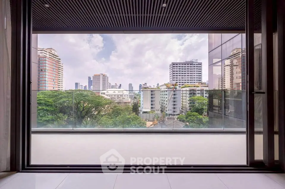 Stunning cityscape view from modern balcony with glass railing in urban high-rise.