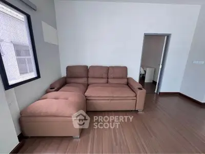 Spacious living room with modern brown sectional sofa and wooden flooring