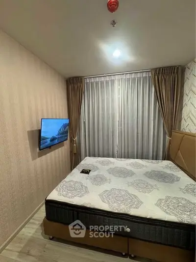 Cozy bedroom with modern decor and wall-mounted TV, perfect for relaxation.