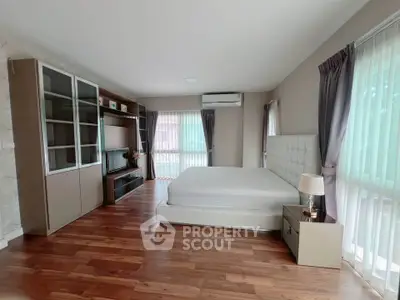 Spacious bedroom with modern decor and large windows for natural light