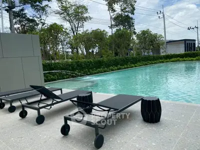 Luxurious outdoor pool area with modern sun loungers and lush greenery.