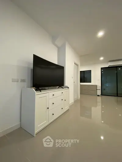 Modern living room with sleek TV stand and glossy tiled flooring