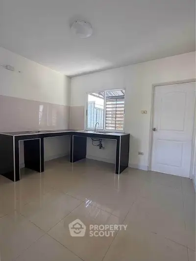 Spacious kitchen with modern black countertops and ample natural light.