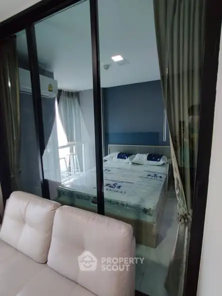 Modern bedroom with glass partition and stylish decor in a contemporary apartment.