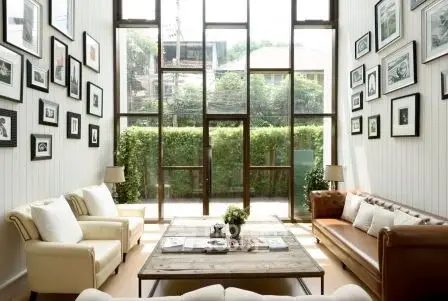 Spacious living room with high ceilings and large windows offering abundant natural light and garden view.