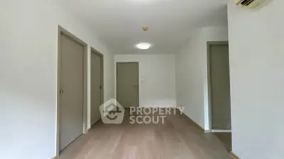 Spacious empty room with wooden flooring and neutral walls, ideal for customization.