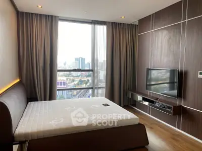 Modern bedroom with large window offering stunning city view, featuring sleek furniture and wooden flooring.